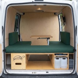 Van interior with unfolded dining table and seating area in Vacamod setup