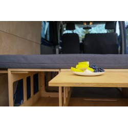 Ansicht von der Rückseite des Vans auf den ausgezogenen Couchtisch und die ausgeklappte BASIC Bettplattform