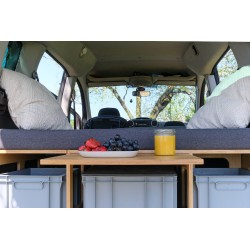 Rear view of a car with an extended pull-out table from the Vacamod camping box, with fresh fruits prepared on top