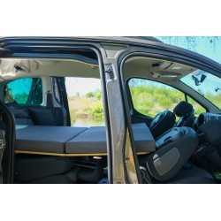 Vacamod car bed unfolded with a foam mattress over the folded backrests of the front and rear passenger seats