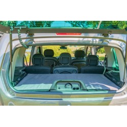View through the rear window of the car showing folded mattresses and the Vacamod camping box, leaving passenger space free