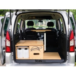 Złożony brązowy campingbox Vacamod KombiVan SOLO PREMIUM ze schowanym łóżkiem i rozłożonym stolikiem.