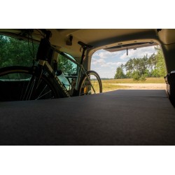 Mattress-level view of fully unfolded Vacamod SOLO single bed with a bicycle in the background and a view of nature.